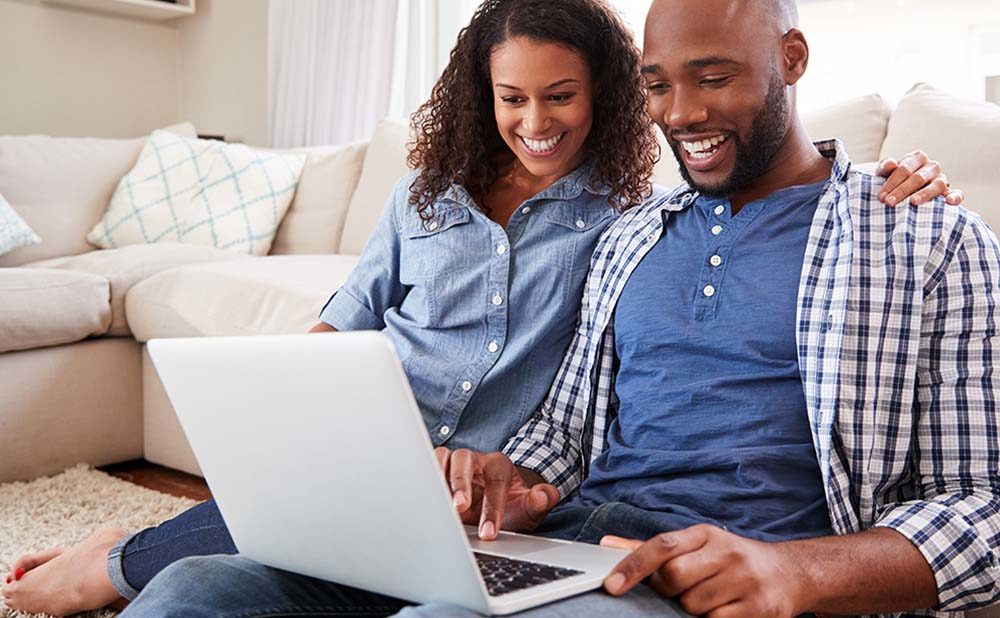 Couple sitting on the couch putting a down payment on a home