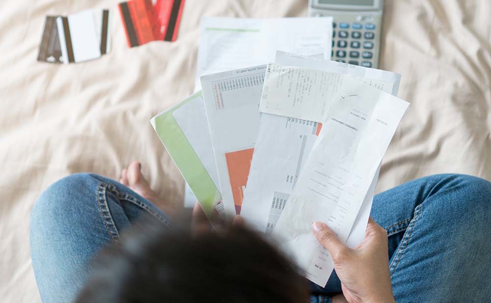 Woman Looking at Debts She Needs to Pay Off